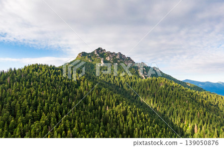 Aerial view to Mala Fatra mountains in Slovakia. Sunrise above mountain peaks and hills in far. Beautiful nature, vibrant colors. Famous tourist destination for hiking and trekking. Cloudy weather. Aerial view to Mala Fatra mountains in Slovakia. Sunrise above mountain peaks and hills in far. Beautiful nature, vibrant colors. Famous tourist destination for hiking and trekking. Cloudy weather. 139050876