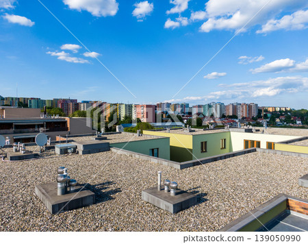 Aerial view of house flat roof on residental building. Modern architecture exterior. Air conditioning systems and ventilation structure. Residental building in background, sunny day Aerial view of house flat roof on residental building. Modern architecture exterior. Air conditioning systems and ventilation structure. Residental building in background, sunny day 139050990