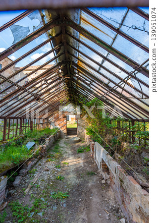 Look to old ruined greenhouse. Broken ancient greenhouse with broken windows Look to old ruined greenhouse. Broken ancient greenhouse with broken windows 139051074