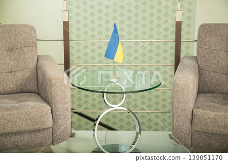 Modern armchairs and table with Ukrainian flag in office. Modern armchairs and table with Ukrainian flag in office. 139051170