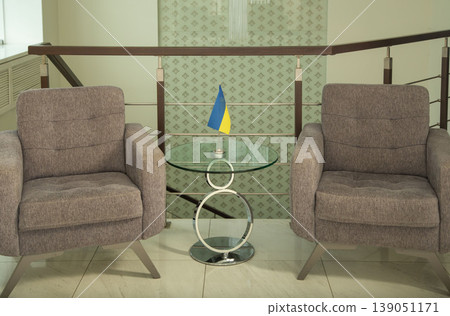 Modern armchairs and table with Ukrainian flag in office. Modern armchairs and table with Ukrainian flag in office. 139051171