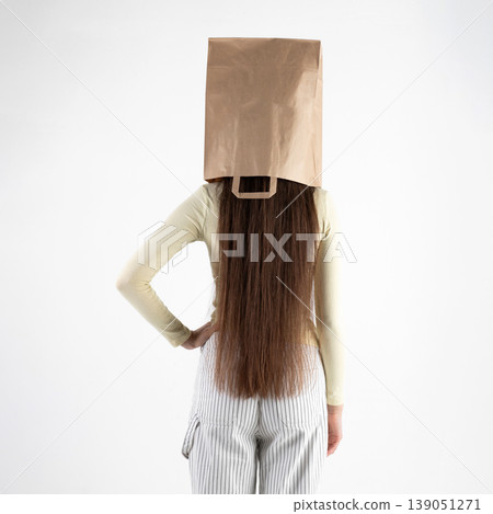 Person standing with brown paper bag on head hiding identity Person standing with brown paper bag on head hiding identity 139051271
