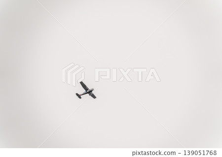 Small ultralight airplane with overhead wing and single propeller flying in sunset sky. Small ultralight airplane with overhead wing and single propeller flying in sunset sky. 139051768