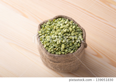 Green pea in linen bag on wooden table. Little bag with split green pea Green pea in linen bag on wooden table. Little bag with split green pea 139051830
