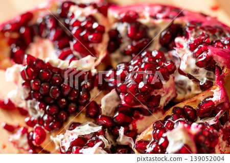 Close up of a pomegranate fruit, cut into many pieces. Juicy red pomegranate seeds, good for health, rich on vitamins Close up of a pomegranate fruit, cut into many pieces. Juicy red pomegranate seeds, good for health, rich on vitamins 139052004