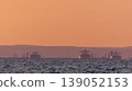 Oil tankers resting in calm sea during sunset 139052153