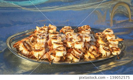 Grilled shrimp skewers arranged on a metal plate with golden char marks and juicy texture. Concept of shrimp cooking, seafood dining, and outdoor barbecue enjoyment Grilled shrimp skewers arranged on a metal plate with golden char marks and juicy texture. Concept of shrimp cooking, seafood dining, and outdoor barbecue enjoyment 139052575