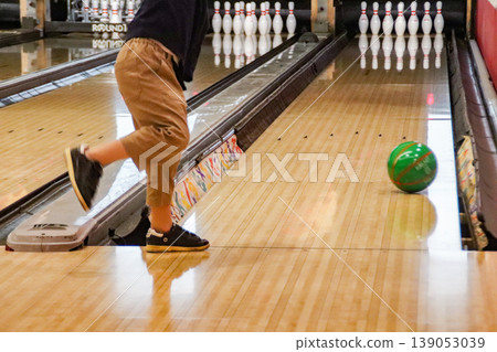 A child (8-year-old boy) playing bowling. A child (8-year-old boy) playing bowling. 139053039