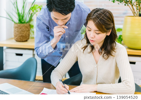 A young couple struggles while keeping a household budget. A young couple struggles while keeping a household budget. 139054520