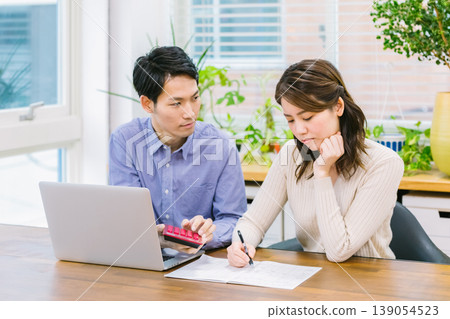 A young couple struggles while keeping a household budget. 139054523