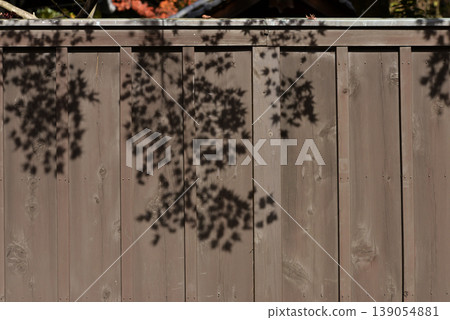 The shadows of maple leaves cast on the wooden fence of Shimogamo Shrine The shadows of maple leaves cast on the wooden fence of Shimogamo Shrine 139054881