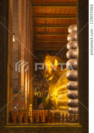 Golden Reclining Buddha statue inside a richly decorated temple in Southeast Asia Golden Reclining Buddha statue inside a richly decorated temple in Southeast Asia 139055068