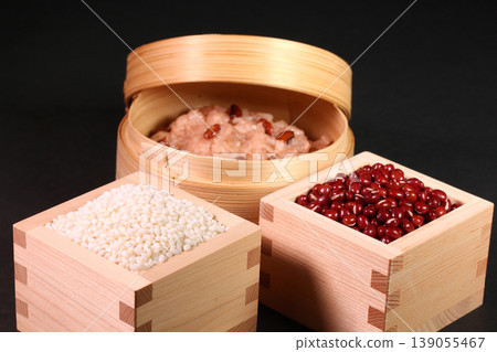Red bean rice in a steamer basket, and red beans and glutinous rice served in a wooden measuring box. Red bean rice in a steamer basket, and red beans and glutinous rice served in a wooden measuring box. 139055467