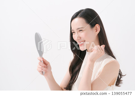 有手鏡的一名微笑的婦女 139055477