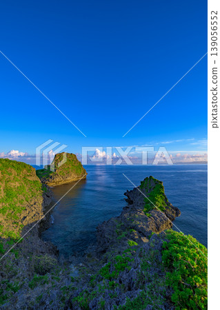 The breathtaking scenery of Cape Maeda, with its striking contrast between lush green cliffs and crystal-clear sea. The breathtaking scenery of Cape Maeda, with its striking contrast between lush green cliffs and crystal-clear sea. 139056552