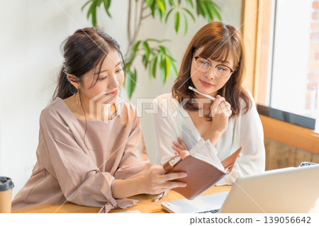 兩個年輕婦女有辦公室的形象 兩個年輕婦女有辦公室的形象 139056642