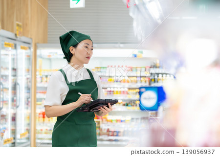 A woman who manages merchandise at a supermarket A woman who manages merchandise at a supermarket 139056937