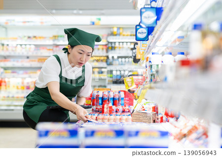 A woman who manages merchandise at a supermarket A woman who manages merchandise at a supermarket 139056943