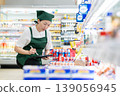 A woman who manages merchandise at a supermarket 139056945