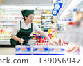 A woman who manages merchandise at a supermarket 139056947
