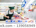 A woman who manages merchandise at a supermarket 139056949