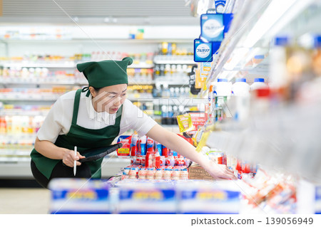 A woman who manages merchandise at a supermarket 139056949