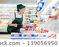A woman who manages merchandise at a supermarket 139056950