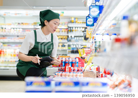 A woman who manages merchandise at a supermarket A woman who manages merchandise at a supermarket 139056950