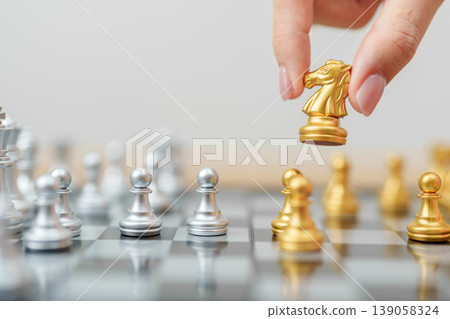 hand moving gold Chess knight figure and Checkmate opponent during chessboard competition. Strategy, Success, management, business planning, win, disruption, Trade war and leadership concept hand moving gold Chess knight figure and Checkmate opponent during chessboard competition. Strategy, Success, management, business planning, win, disruption, Trade war and leadership concept 139058324