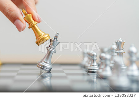 hand moving gold Chess King figure and Checkmate opponent during chessboard competition. Strategy, Success, management, business planning, win, disruption, Trade war and leadership concept hand moving gold Chess King figure and Checkmate opponent during chessboard competition. Strategy, Success, management, business planning, win, disruption, Trade war and leadership concept 139058327