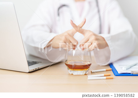 doctor hand making stop sign to refuse whiskey and breaking cigarette, quit smoking and drinking for healthy liver and lung, World No Tobacco and No Alcohol Day and stop alcohol addiction concept doctor hand making stop sign to refuse whiskey and breaking cigarette, quit smoking and drinking for healthy liver and lung, World No Tobacco and No Alcohol Day and stop alcohol addiction concept 139058582