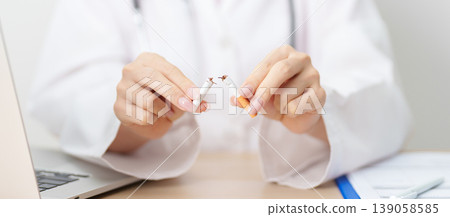 doctor hand making stop sign to refuse and breaking cigarette, quitting smoking for healthy lungs, prevent Lung Cancer and Emphysema, World No Tobacco Day concept 139058585