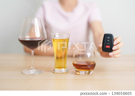 Responsible woman reject a drink before driving for road safety, stop hand gesture to refuse a glass of wine, beer, whiskey or cognac and car remote. Avoid drink and drive, Drunk Driving Law concept Responsible woman reject a drink before driving for road safety, stop hand gesture to refuse a glass of wine, beer, whiskey or cognac and car remote. Avoid drink and drive, Drunk Driving Law concept 139058605