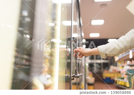 Hands opening the refrigerated display case at the supermarket Hands opening the refrigerated display case at the supermarket 139058898