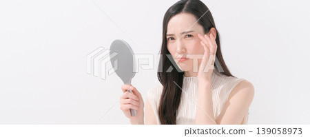 A woman looking in the mirror and feeling troubled (banner) A woman looking in the mirror and feeling troubled (banner) 139058973