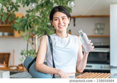 亞洲女性在家訓練後用瓶裝礦泉水補水 139058984