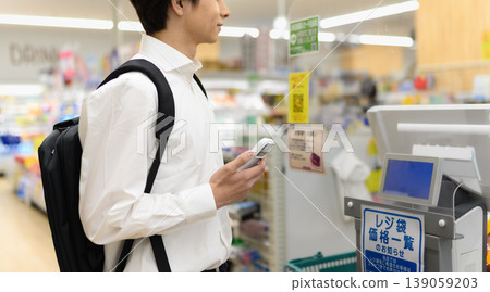 一名男子在超市用智慧型手機支付購物款項。 139059203