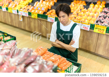 A male store clerk at the supermarket is troubled. 139059218
