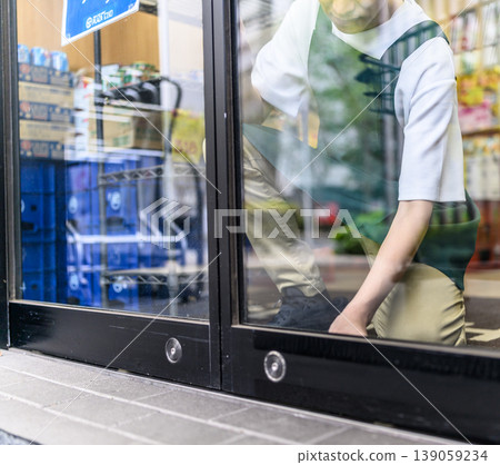 The shop assistant is tying the shoelaces. 139059234