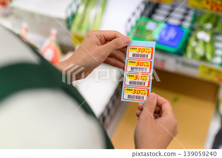 Shoppers check the discount stickers. 139059240