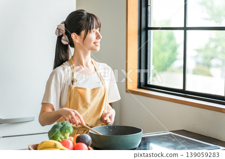 Young Asian woman cooking in the kitchen (cooking, home cooking) Young Asian woman cooking in the kitchen (cooking, home cooking) 139059283