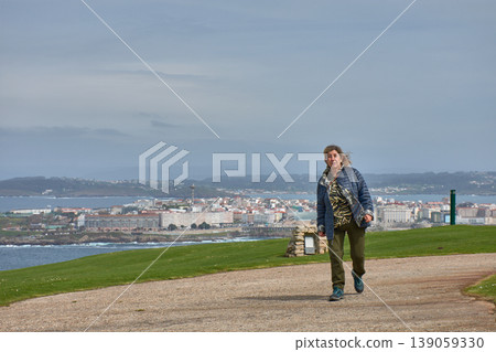 Woman strolling through Monte de San Pedro Park in A Coruna with panoramic views of the city. 139059330