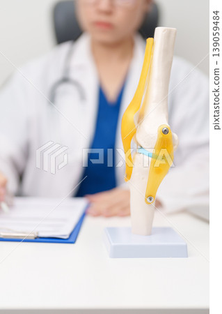 Doctor with Human Knee joint anatomy model. Osteoarthritis, Patellofemoral Pain Syndrome, Patellar Tendinitis, ACL, Anterior Cruciate Ligament, PCL, Posterior, MCL, Medial Collateral, LCL and Lateral 139059484