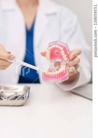 Dentist with tooth Anatomy model. Oral Teeth and disease, Scrape off tartar. March Oral health, Dentist Day, False Teeth. Toothache and Children Dental Health Month and Orthodontic Health Day Dentist with tooth Anatomy model. Oral Teeth and disease, Scrape off tartar. March Oral health, Dentist Day, False Teeth. Toothache and Children Dental Health Month and Orthodontic Health Day 139059551