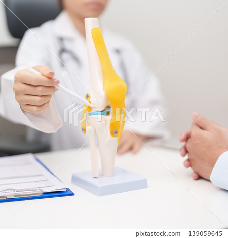 Doctor with Human Knee joint anatomy model. Osteoarthritis, Patellofemoral Pain Syndrome, Patellar Tendinitis, ACL, Anterior Cruciate Ligament, PCL, Posterior, MCL, Medial Collateral, LCL and Lateral Doctor with Human Knee joint anatomy model. Osteoarthritis, Patellofemoral Pain Syndrome, Patellar Tendinitis, ACL, Anterior Cruciate Ligament, PCL, Posterior, MCL, Medial Collateral, LCL and Lateral 139059645