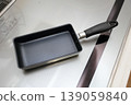 A frying pan for making omelets placed on an induction cooktop. 139059840