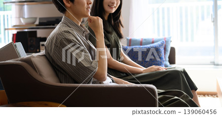 Torso of a man and woman sitting on a sofa Torso of a man and woman sitting on a sofa 139060456