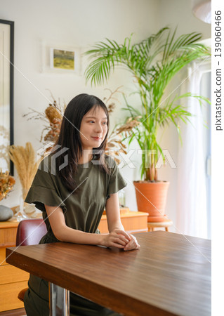 Portrait of a young woman sitting by a window Portrait of a young woman sitting by a window 139060466