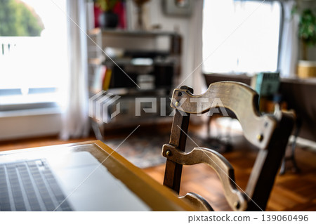 A desk and wooden chair by the window 139060496