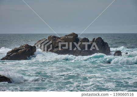 The immensity of the Atlantic Ocean crashing against a solitary rock on the coast on a day of rough seas The immensity of the Atlantic Ocean crashing against a solitary rock on the coast on a day of rough seas 139060516